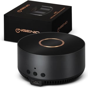 A black wireless charging speaker with a sleek design, featuring control buttons and a logo, alongside its packaging.