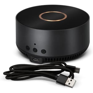 A wireless charging speaker in black with a gold accent, accompanied by a USB cable.