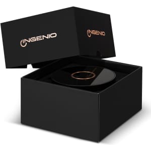 A wireless charging speaker in a sleek black box, featuring a logo on the packaging. The speaker surface is glossy and black.