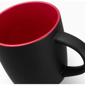 A coffee mug with a matte black exterior and a red interior, featuring a handle and a logo.