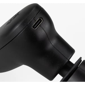 A compact handheld massager in sleek black, featuring a charging port and ergonomic design.