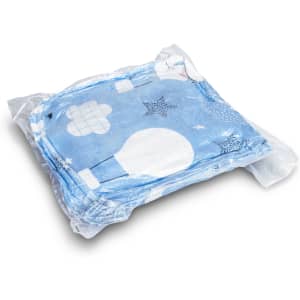 A blue patterned blanket hoodie is neatly packaged in transparent plastic. It features various designs and textures.