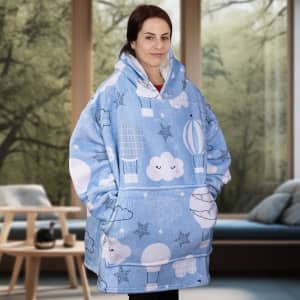 A blue blanket hoodie featuring cloud and balloon patterns, with a spacious, oversized design and a logo.