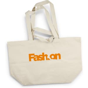 A cream tote bag with orange text and longer straps. The bag has a logo on one side.