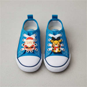 A pair of blue shoes featuring custom shoe charms with Santa and a reindeer design.