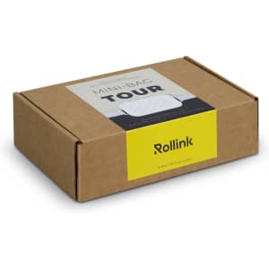 A brown cardboard box containing the Rollink Mini Bag Tour product, featuring a logo and colourful design elements.