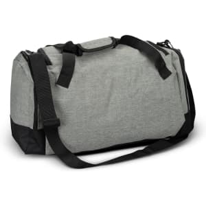 A grey duffle bag with black accents, featuring dual handles and a removable shoulder strap. It has a logo on the side.