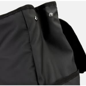 A black backpack featuring a textured fabric, with a closure flap and buttons at the top. It has a logo present.