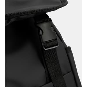 A close-up of a black soft-touch backpack featuring a clip and adjustable strap. The material appears durable.