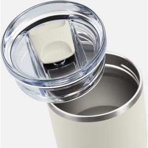 A drink bottle with a stainless steel body, featuring a clear lid and a white push button. It has a sleek design.