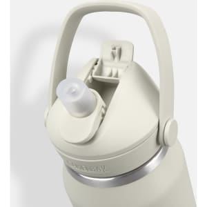 A drink bottle in light grey with a flip straw lid and a handle. It features a logo on the side.