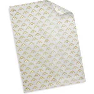 A sheet of white tissue paper with a subtle gold geometric pattern and a branding logo.