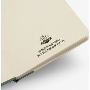 A beige notebook made from 80% sugarcane waste, featuring a branded logo on the cover.