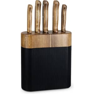 A knife block with a wooden base and five knives featuring textured black handles.