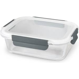 A glass lunch box with a transparent lid and grey clips for secure sealing. Suitable for storing meals.