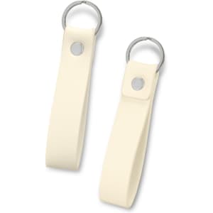 A cream-coloured key ring with a smooth leather-like strap and a metal ring attached. It features a silver button.