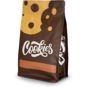 A small foil flat bottom pouch in brown with a cookie design and a logo on the front.