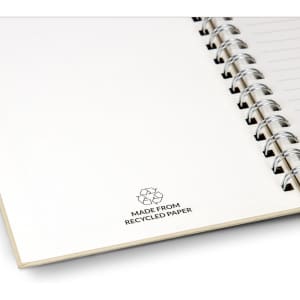 A recycled paper spiral notebook with a white cover and a silver spiral binding, featuring a recycling symbol.
