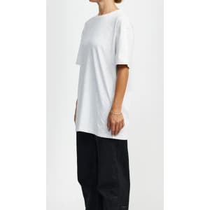 A light grey t-shirt with a relaxed fit, featuring short sleeves, displayed on a model alongside black trousers.