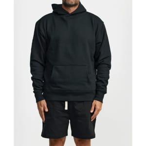 A black hoodie with a front pocket and a hood, paired with black shorts. The model stands in a neutral position.