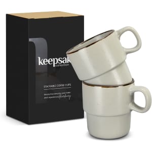 A stack of two light grey coffee cups with dark rims, packaged in a branded box.