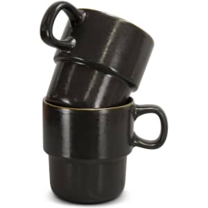 A stack of two black ceramic coffee mugs with a glossy finish and golden rims, featuring handles.