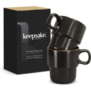 A set of two black stackable coffee cups displayed in a box, featuring a logo on the front.