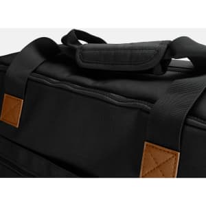 A black duffle bag with padded handles and tan leather accents. The material appears sturdy and durable.