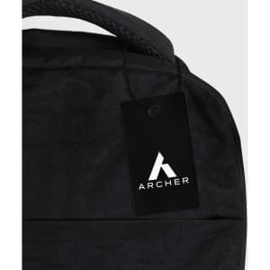 A black backpack with a textured surface and an attached tag featuring a logo.