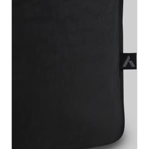 A black tote bag with a textured surface and a small branding tag.