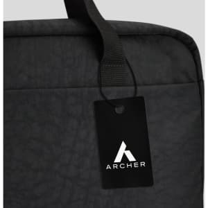 A black laptop bag featuring a top handle and a tag with a logo. The material has a textured finish.