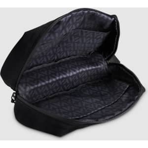 A black toiletry bag with a zippered opening, featuring multiple compartments and a patterned interior.