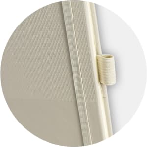 A light beige notebook with a textured cover and a strap closure. It features a logo on the cover.