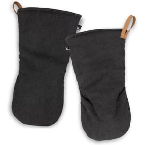 Two black canvas oven mitts with a loop for hanging and a branding label on one.