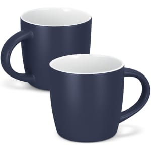 A drinkware set featuring two navy blue coffee mugs with white interiors and curved handles. One mug is slightly behind the other.