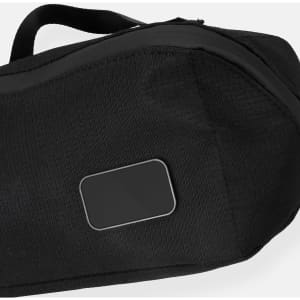 A black toiletry bag featuring a smooth panel and a sturdy handle, ideal for travel and storage.