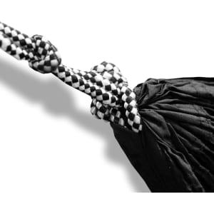 A black and white hammock with intricate knotting details, featuring a checkered pattern on the rope.