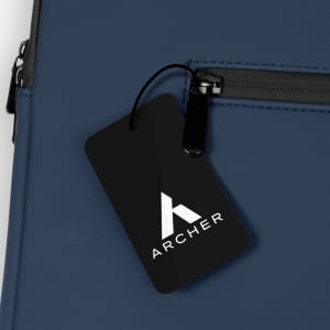 A navy blue soft-touch laptop sleeve featuring a zippered pocket and a branded tag.