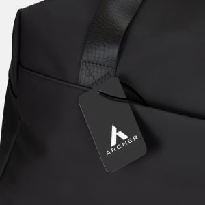 A black soft-touch duffle bag featuring a logo and a stylish tag. The bag has a sleek, minimalistic design.