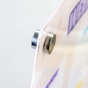 A magnetic fastener holding a clear, colourful planner, with various pastel shades visible on the surface.