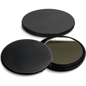 A black compact mirror with a smooth exterior, featuring a reflective surface inside. It has a circular shape.