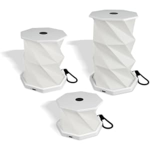 A white foldable lantern with a geometric design, featuring a handle for carrying. It is shown in three different sizes.
