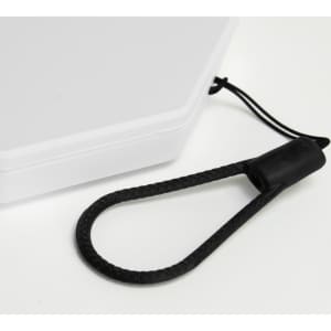 A foldable lantern in white with a black carrying strap attached. The design includes a compact, rectangular shape.