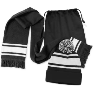 A black scarf with white stripes and a matching black beanie with a pom pom, both in a drawstring bag.