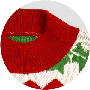 A red and white knitted jumper with a green pattern around the neckline. Features a festive design.