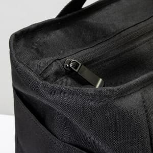 A black cooler bag with a zip closure and textured fabric, featuring an exterior pocket.