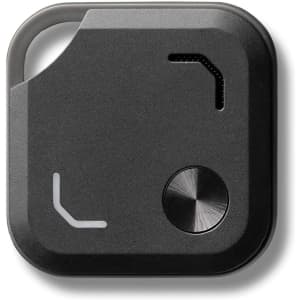 A black Bluetooth tracker featuring a metal button and a small opening, with a minimalist design.