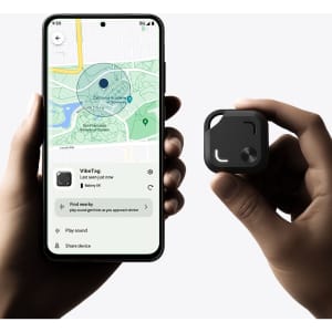 A hand holds a small black Bluetooth tracker next to a smartphone displaying a map and tracking interface.