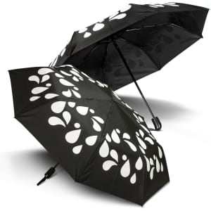 A colour changing compact umbrella in black with white droplet patterns, featuring two opened canopies.