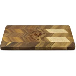 A wooden chopping board with a chevron pattern and a logo engraved on its surface.